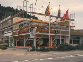 Kilchenmann Geschichte 1989 zeigt Gebäude in Kehrsatz mit Baugerüst